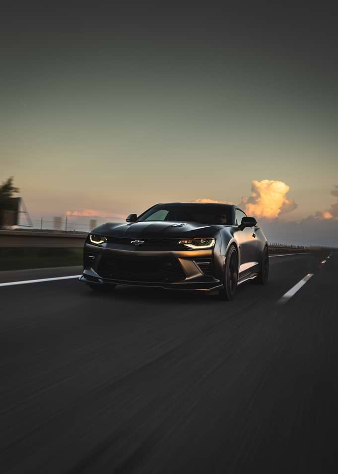 Black Camaro Driving at Sunset