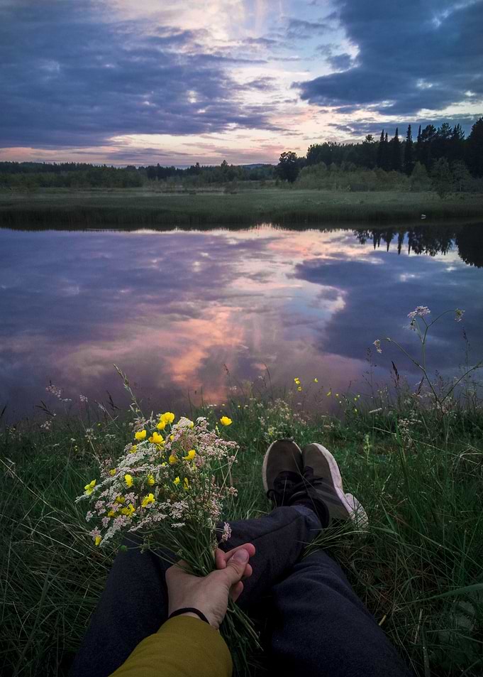 Couple Holding Hands by a Lake at Sunset