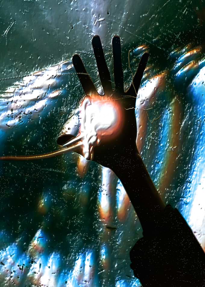 Hand reaching through abstract light and water