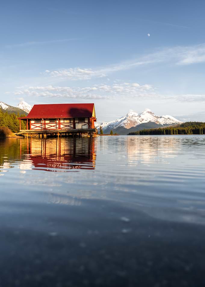 Boathouse on a serene lake with mountains