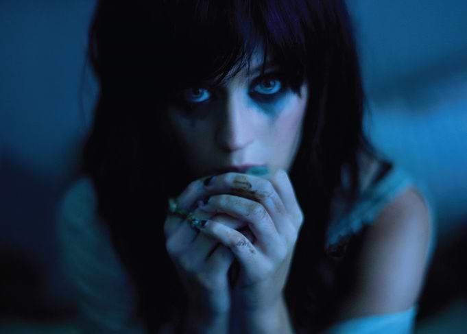 Katy Perry with dark makeup and hands clasped