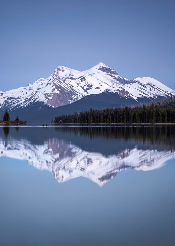Snow-capped mountains reflected in a calm lake