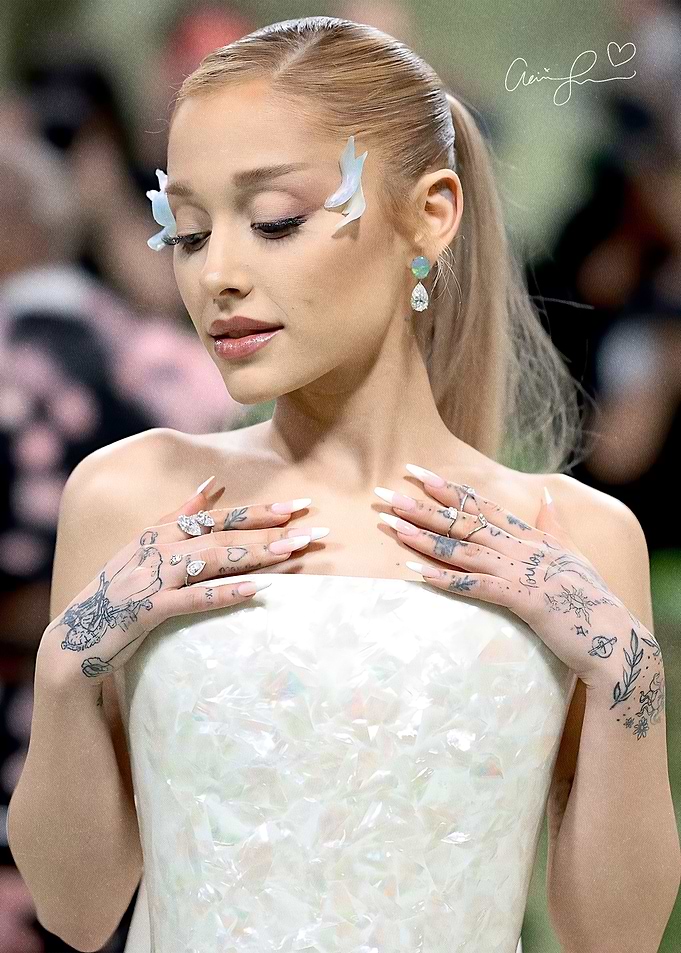 Ariana Grande in a white gown with butterfly accents