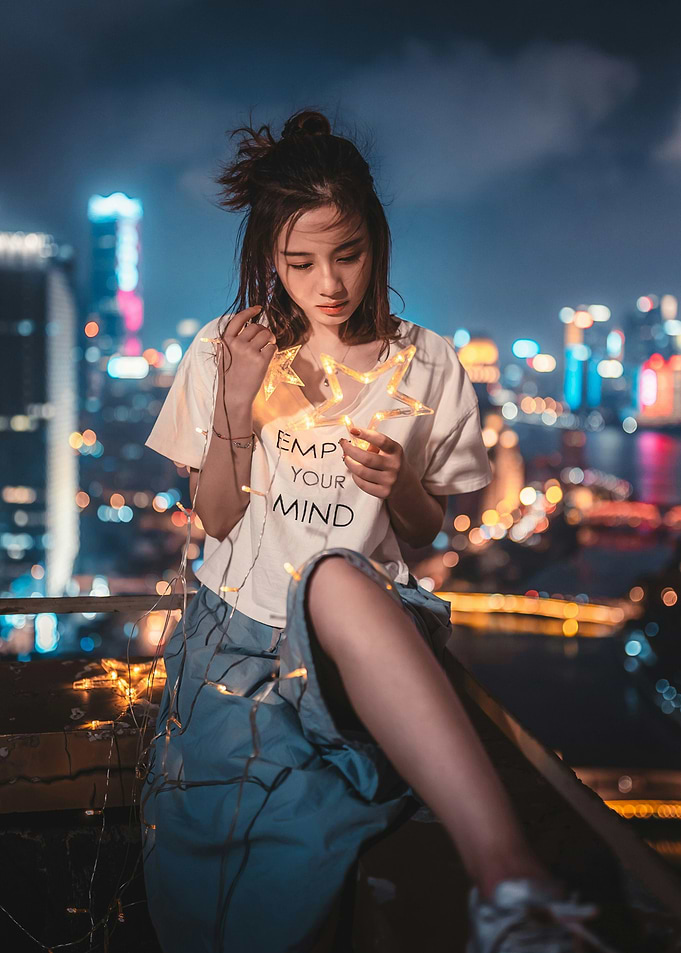 Woman with fairy lights on rooftop