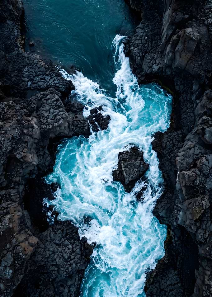 Turquoise River Rushing Through Dark Rocks