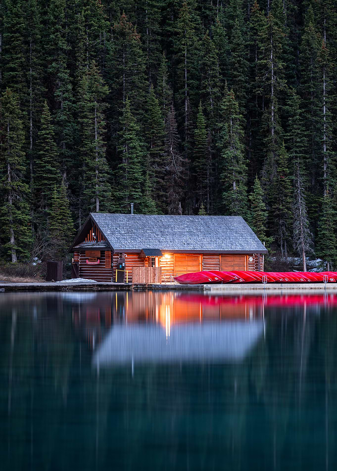 Log Cabin Boathouse on Lake with Canoes