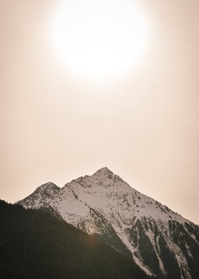 Snow-capped mountain under a bright sky