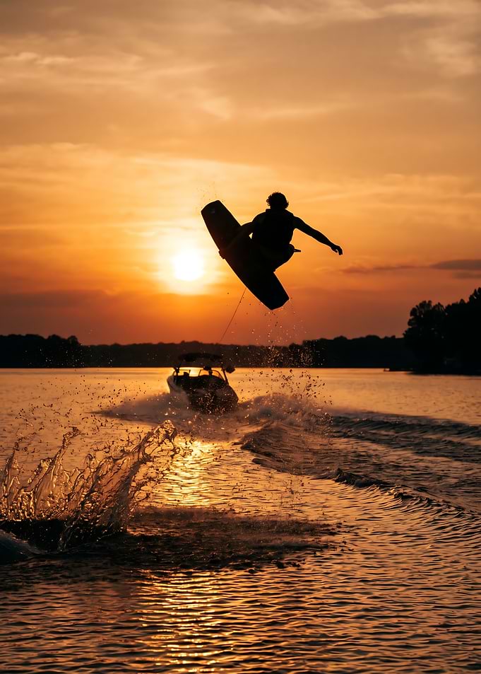 Wakeboarder jumps at sunset