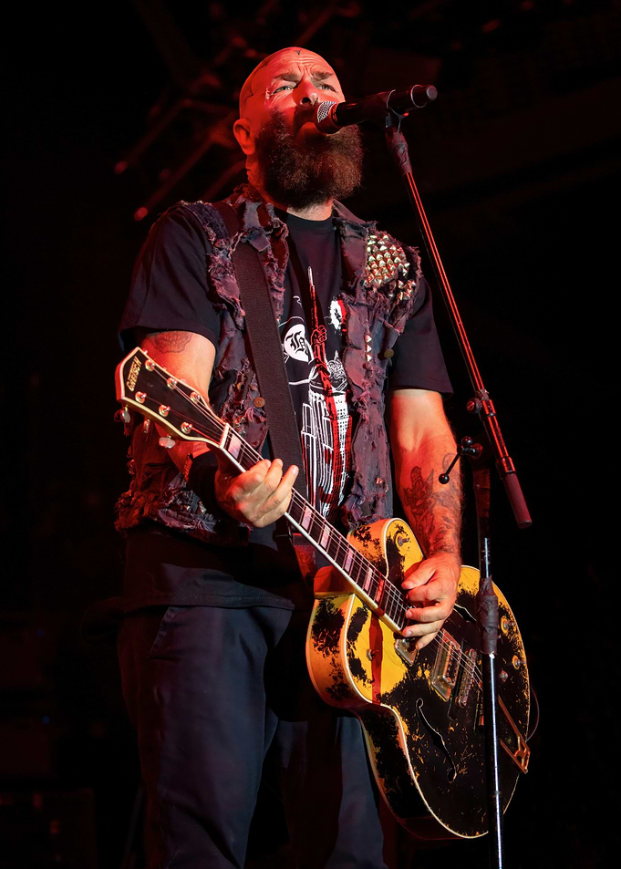Bald Man Playing Guitar on Stage