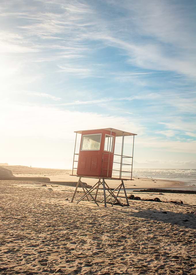 Red lifeguard tower on a sandy beach