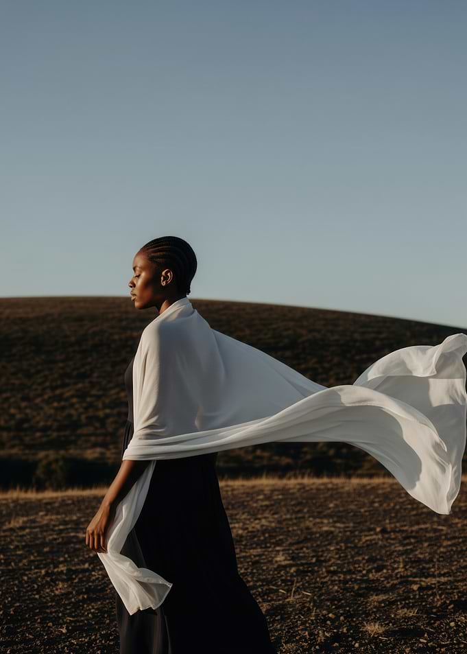 Woman in flowing white scarf in nature