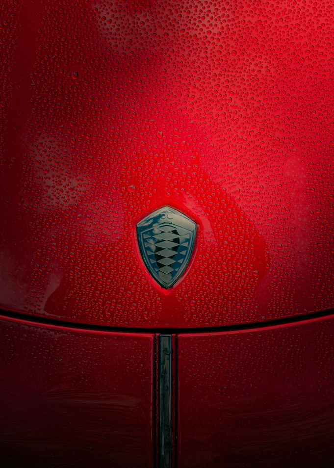 Red Koenigsegg car hood with water droplets