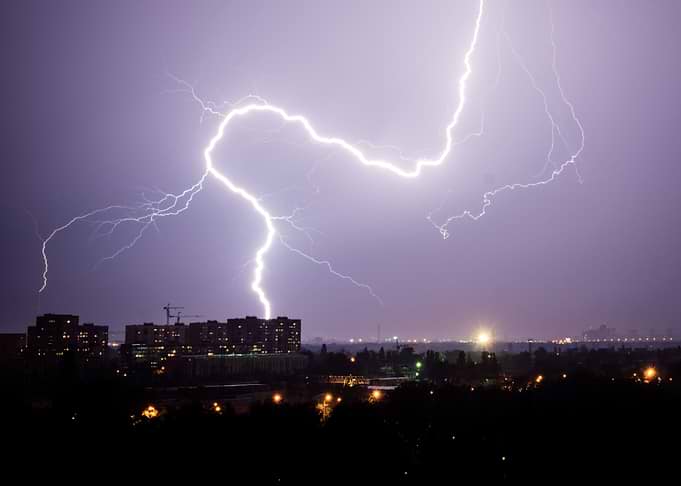Lightning strikes over city at night