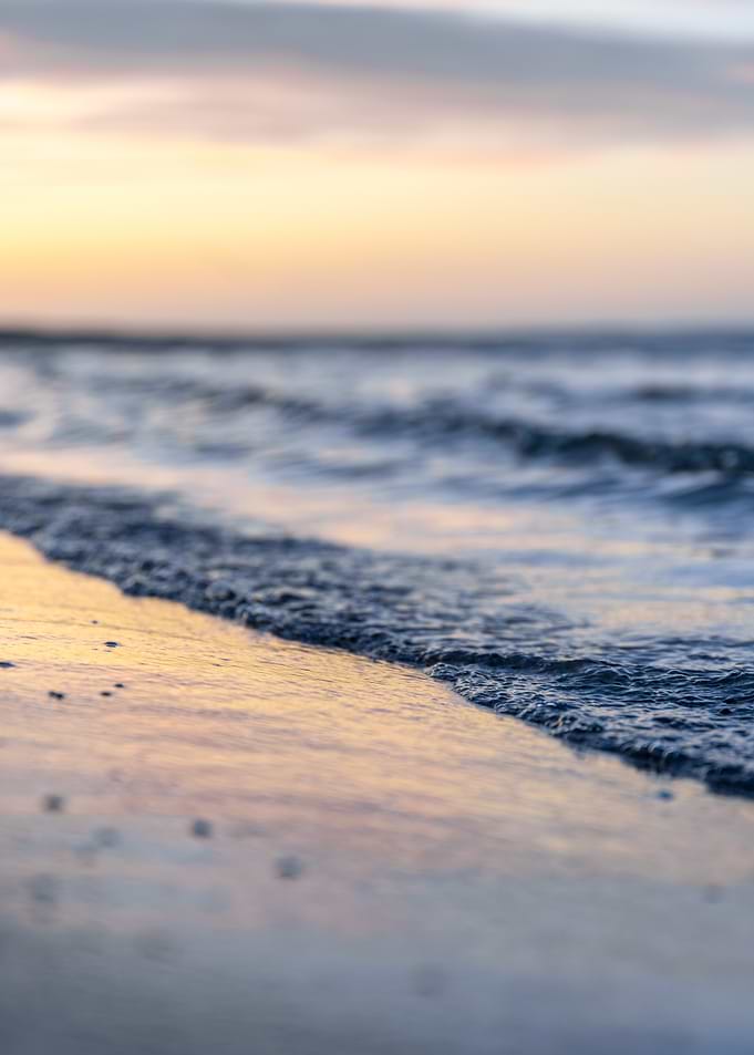 Gentle Waves on a Sandy Beach at Sunset