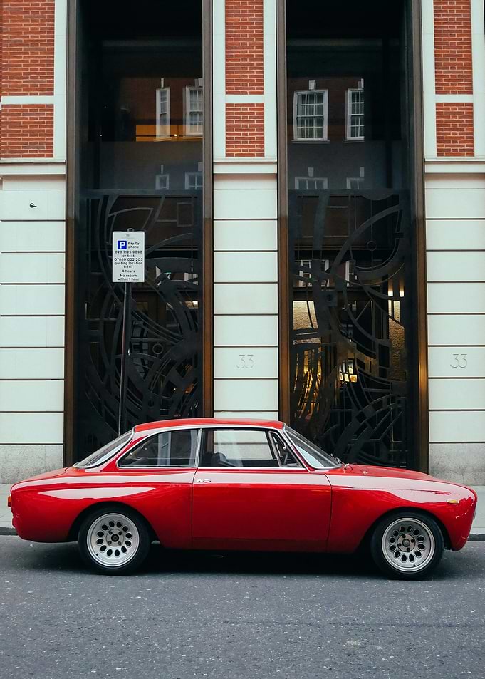 Red Classic Car Parked Outside Building