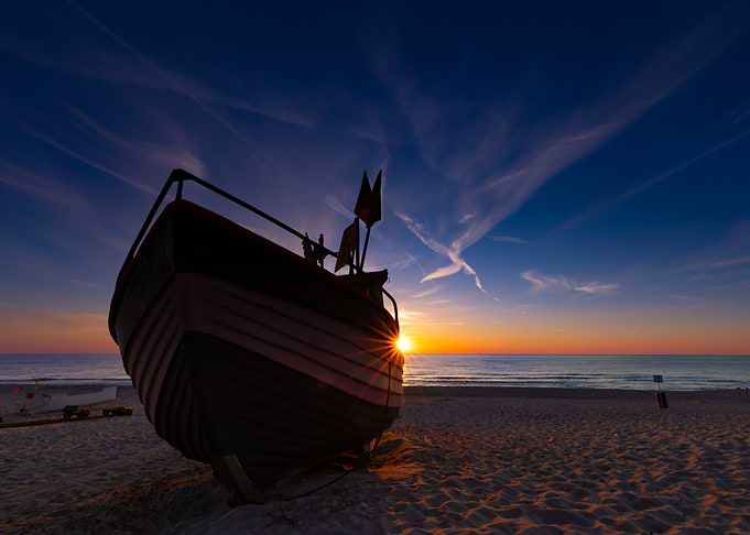 Boat on beach at sunset