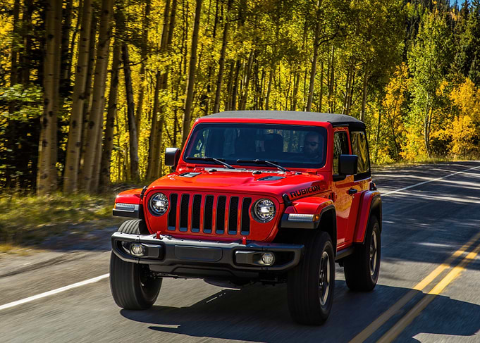 Red Jeep Wrangler Rubicon Driving Through Autumn Forest