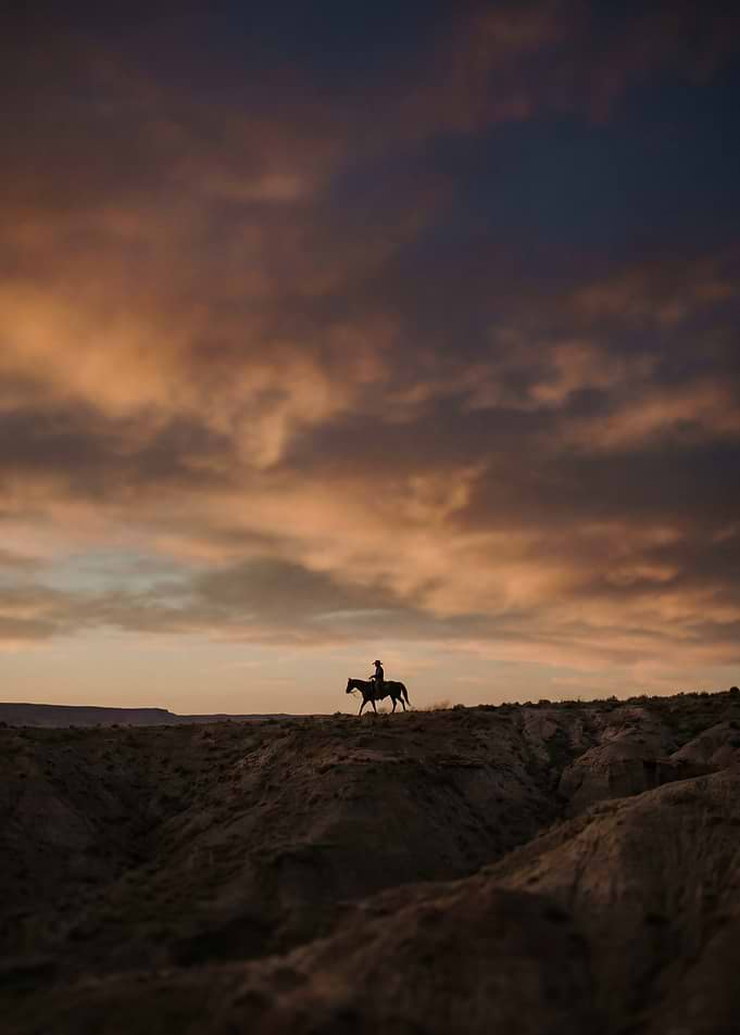 Lone Cowboy Riding at Sunset