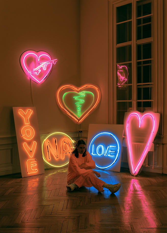 Person Sitting Among Neon Heart Signs