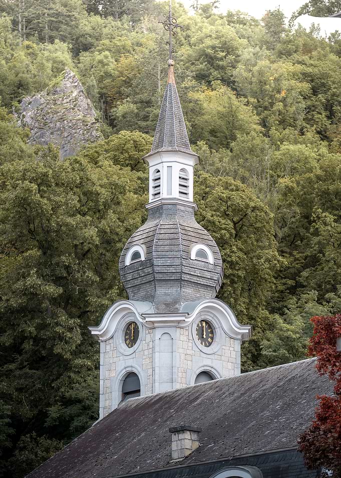 Historic Church Steeple Against Forest