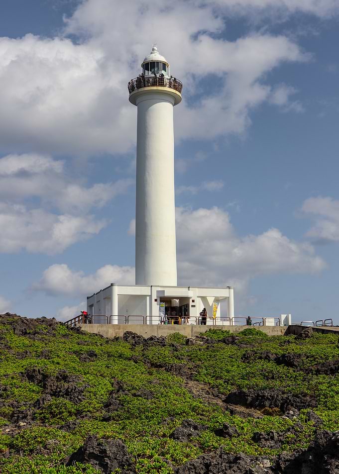 Tall White Lighthouse on Rocky Coast in Japan
