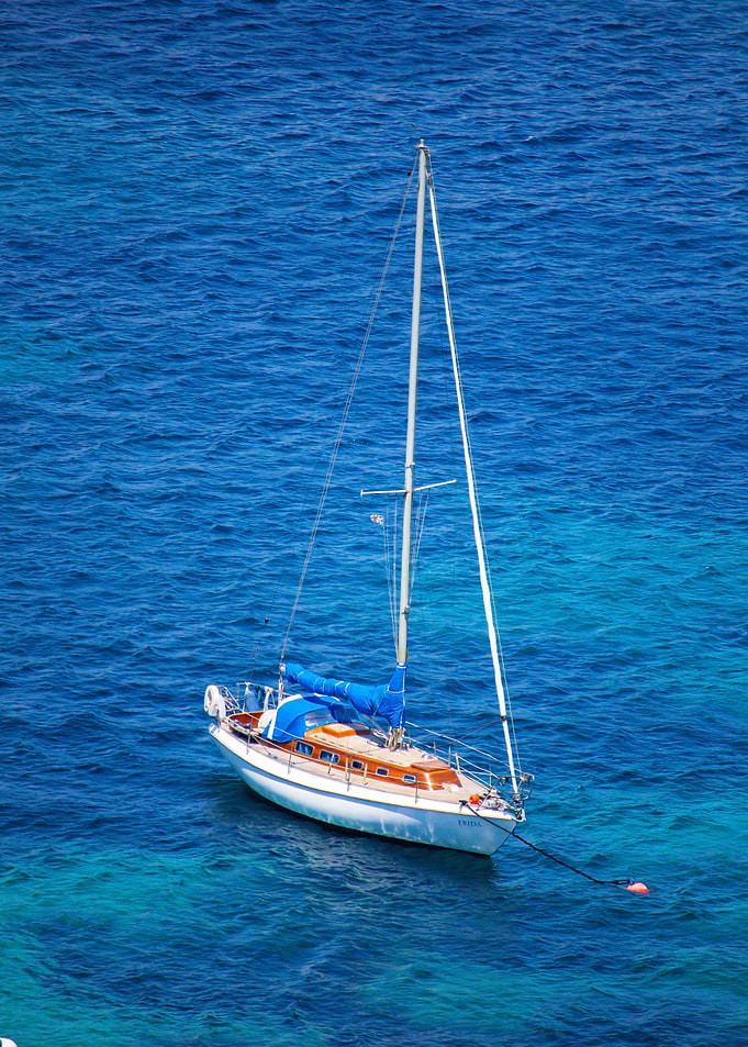 Sailboat anchored in deep blue water