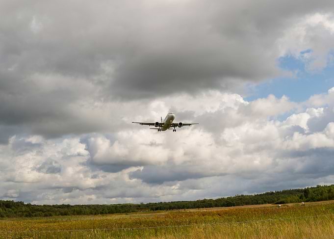 Airplane Landing Under Cloudy Sky