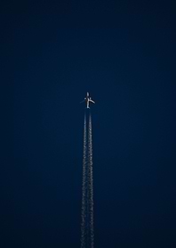 Airplane Flying Through Dark Blue Sky