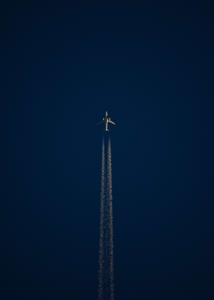 Airplane Flying Through Dark Blue Sky
