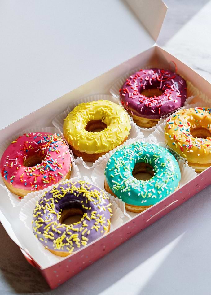 Box of Colorful Glazed Donuts