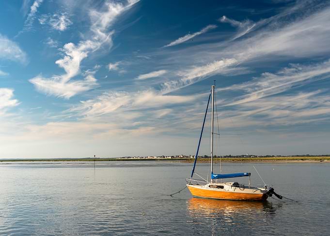 Orange Sailboat Anchored in Calm Waters