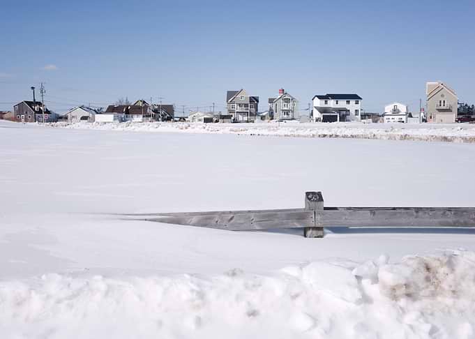 Snowy Coastal Landscape with Houses