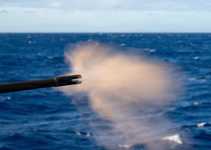 Naval Gun Firing Over Ocean