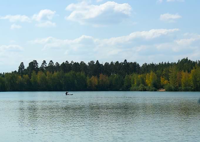 Person paddleboarding on a calm lake