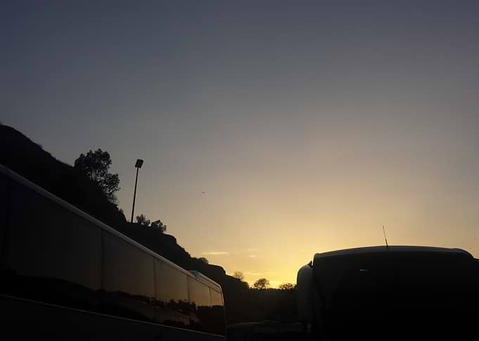 Sunset silhouette of buses on road
