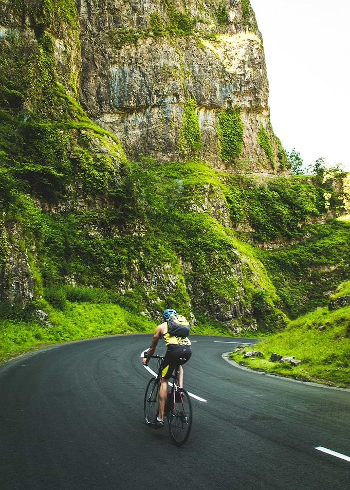 Cyclist Riding Through Mountain Pass