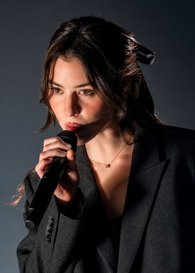 Young Woman Singing into Microphone