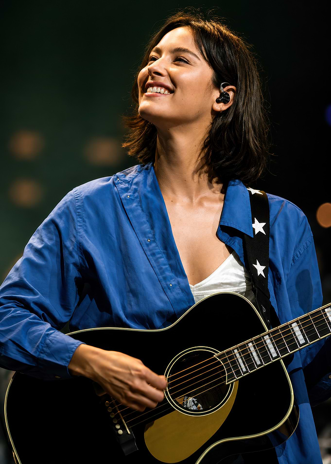 Smiling woman playing acoustic guitar
