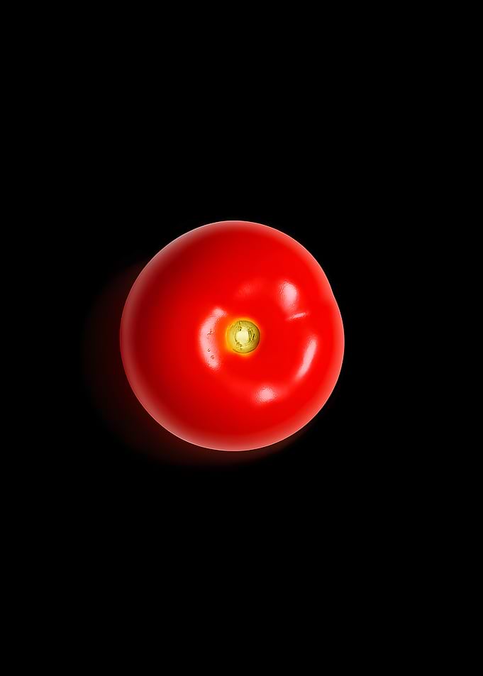 Single Red Tomato on Black Background