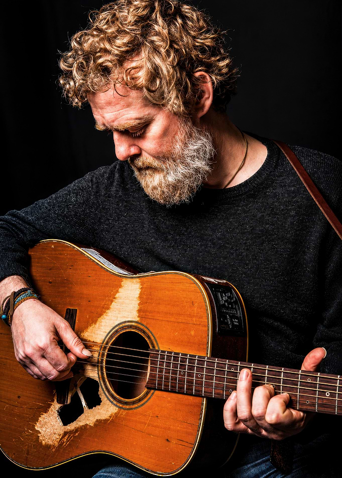 Bearded Musician Playing Worn Acoustic Guitar
