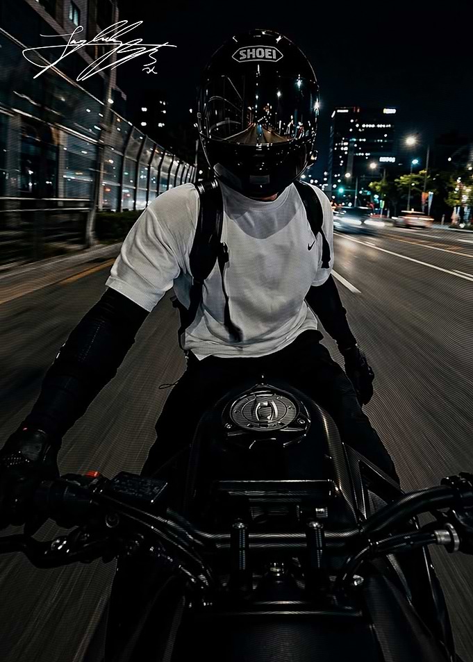 Motorcyclist Riding Through City at Night