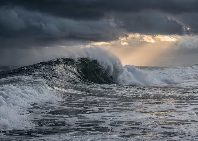 Dramatic Ocean Wave Under Stormy Skies