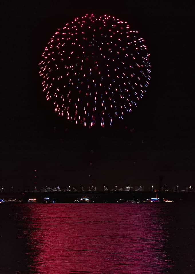 Vibrant Pink Fireworks Over Water