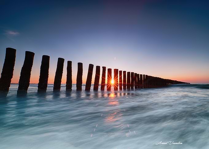 Sunset over wooden beach groynes