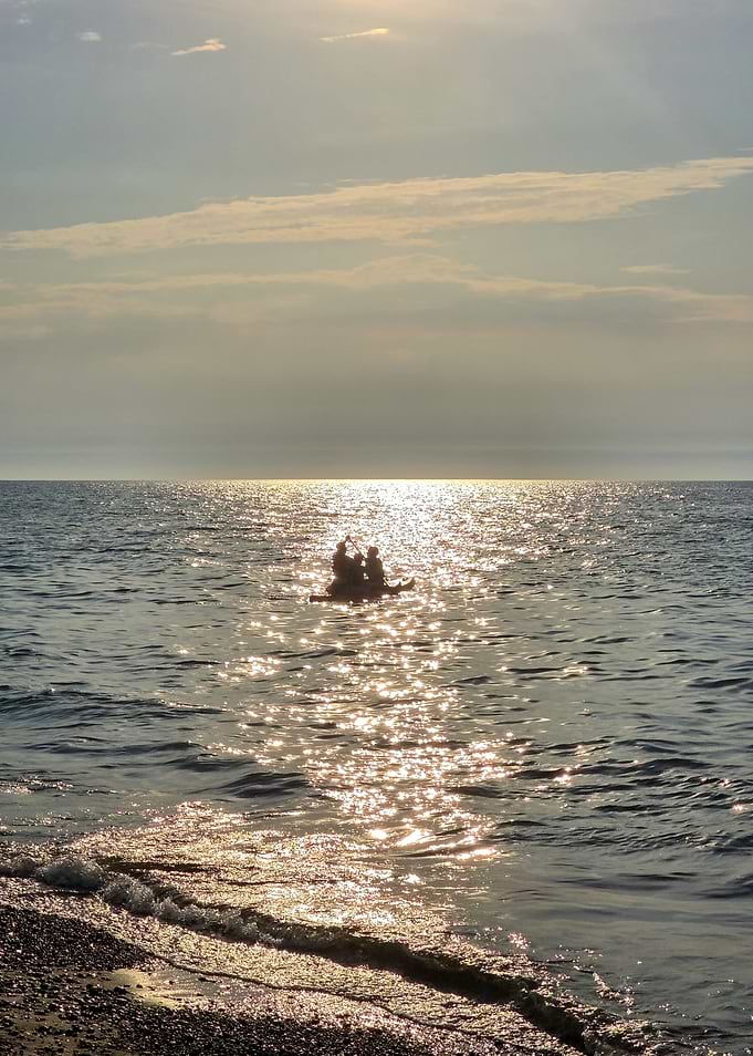 Silhouetted People Kayaking at Sunset