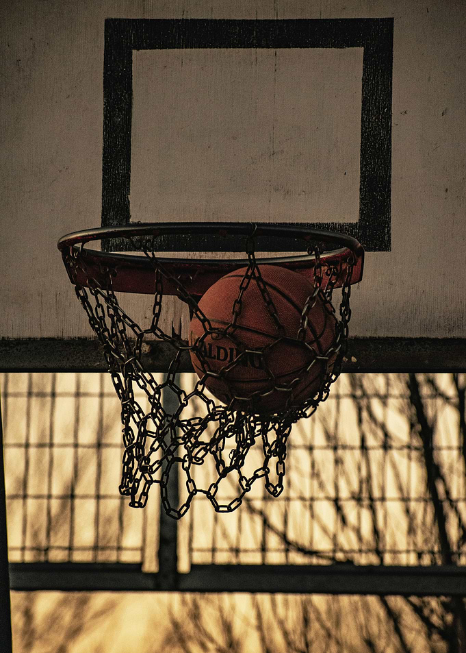 Basketball going through chain net hoop