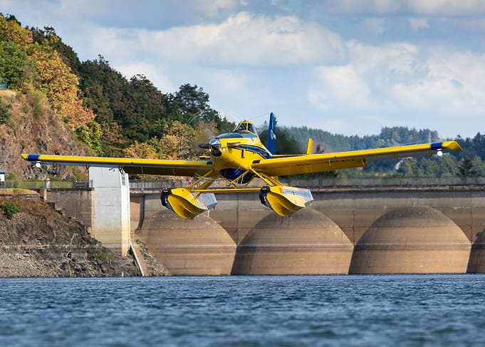 Yellow Air Tractor Flying Over lake