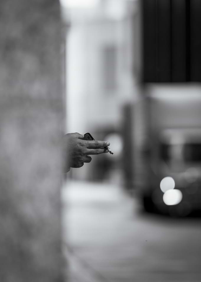 Hand holding cigarette in black and white