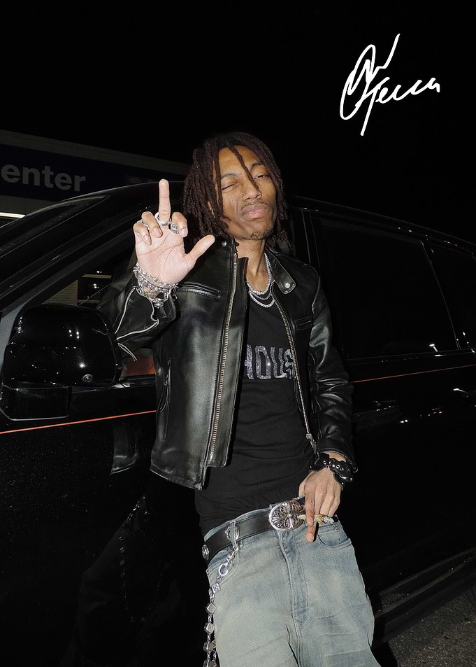 Young man posing by black SUV