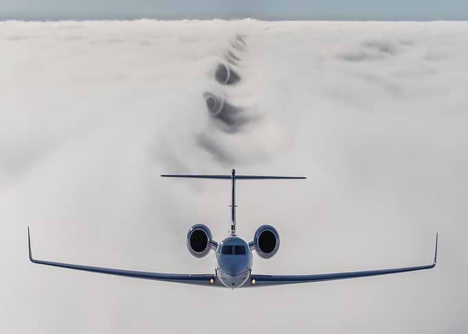 Private Jet Flying Above Clouds